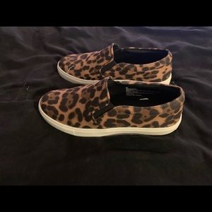 Leopard print slip on woman’s shoes.